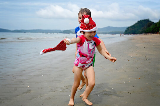 kids in Santa hat on the beach - Powered by Adobe