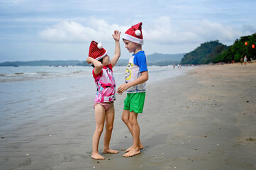 kids in Santa hat on the beach