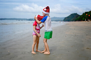 kids in Santa hat on the beach