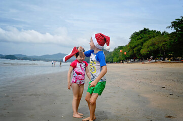 kids in Santa hat on the beach