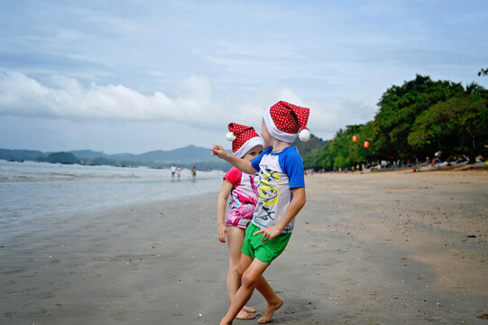 kids in Santa hat on the beach - Powered by Adobe