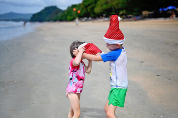 kids in Santa hat on the beach