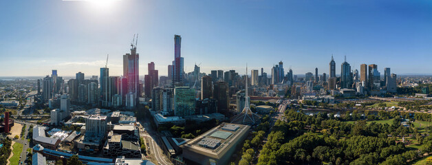 A panoramic view of a modern city skyline with tall skyscrapers, green parks, and urban architecture