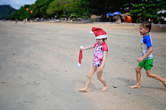 kids in Santa hat on the beach - Powered by Adobe