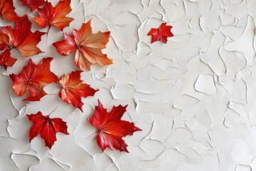 Autumnal red maple leaves arranged on textured white background.