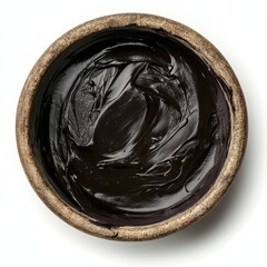 Melted black chocolate in a rustic bowl, top view on a white background