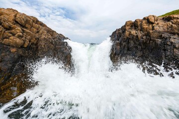 Fototapeta premium Ocean's Fury: Waves Crashing Against Rugged Coastline