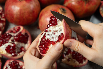 The process of easily opening the pomegranate with a knife, dividing the pomegranate into slices.