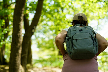 Rear view of a woman with a backpack standing in a forest