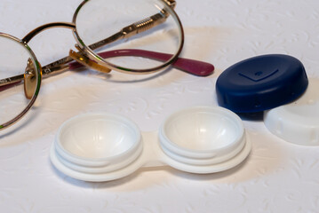 glasses and contact lens holder on white background