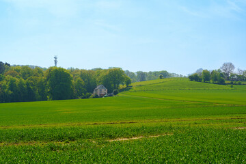 Beautiful spring landscape with green field and farmhouse in Bavaria