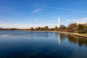 A serene view of the Washington Monument reflecting in the Tidal Basin on a clear autumn day in Washington D.C.