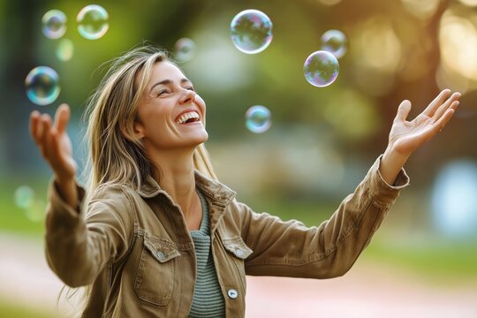 Young woman joyfully blowing soap bubbles with a bright smile on a vibrant pink background