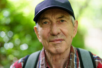Obraz premium Portrait of an elderly man with a cap in the park.