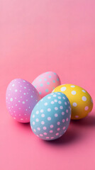 Obraz premium Pastel-colored easter eggs with polka dots rest on a vibrant pink backdrop, embodying the joy and renewal of the spring season
