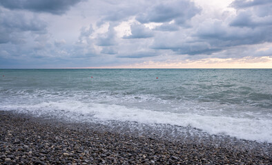 Seashore, small stones, sea wave. Marine background.