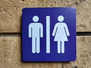 Public restroom sign displayed on a wall indicating gender specifications in a public area