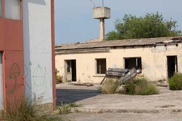Abandoned factory in decay with crumbling walls and broken windows. Industrial ruins showing urban...