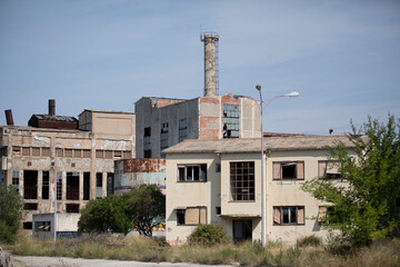 Abandoned factory in decay with crumbling walls and broken windows. Industrial ruins showing urban...