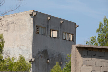 Abandoned factory in decay with crumbling walls and broken windows. Industrial ruins showing urban...