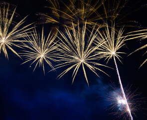 Golden firework sparkling on blue sky with smoke