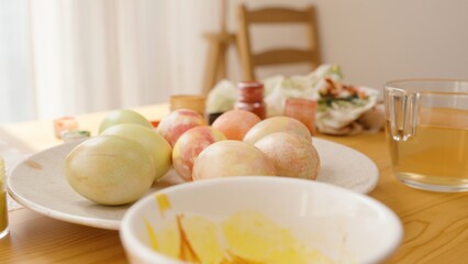 A Plate of Colorfully Painted Easter Eggs Sits on a Table, Surrounded by Painting Supplies.
