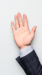 Naklejka premium A hand is raised in the air, with a suit jacket and a striped shirt underneath