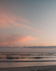 Obraz premium A peaceful sunset scene with ocean waves and sky colors