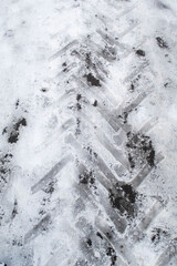 A tire track in the snow with a black and white pattern