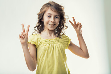 Smiling girl showing victory sign with both hands