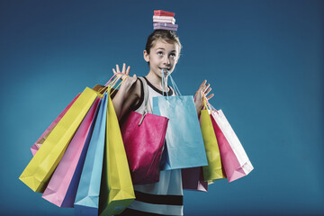Young shopper balancing gifts and shopping bags with joy