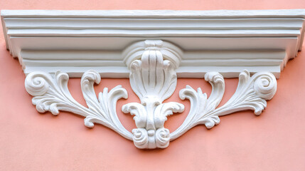 White stucco decoration adorning a peach-colored wall