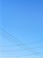 Fototapeta premium Minimalistic photography of a clear sky, beautiful weather, and beautiful interspersed high-voltage power lines.