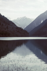 Mirror of Nature: A Peaceful Lake with Mountain Backdrop