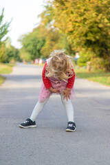 The child fell on the road and hit her leg. Selective focus.