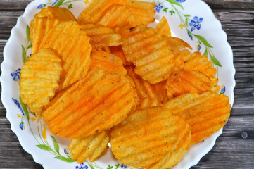 Potato chips crisps, thin slice of potato, thin deposit of potato paste that has been deep fried, baked, or air fried until crunchy, chips are cooked and salted with sizzling chicken flavor