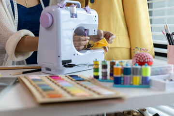 A woman who is running an online clothing business and is also a designer, working on designing...