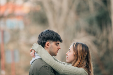 young couple in love hugging on the street