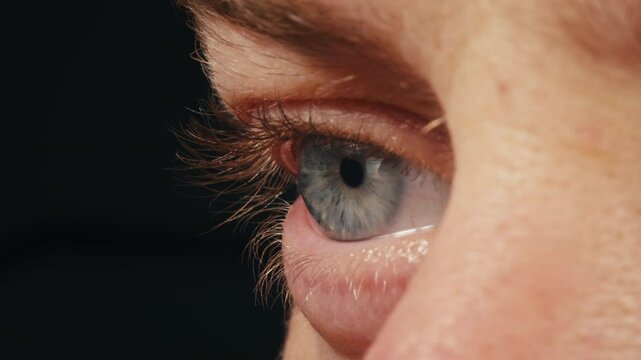 Detailed blue eye with strong gaze, showing human anatomy and beauty, thriller depression halloween style. Drugs concept.