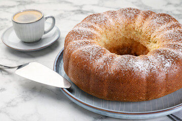Freshly baked sponge cake, server and coffee on white marble table, closeup