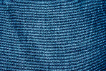Texture of vintage blue jeans with abrasions.