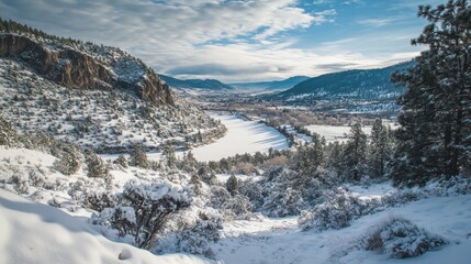 Snow-covered mountains and a serene river under a cloudy sky during winter in a remote landscape
