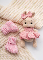 Fototapeta premium Variety of knitted toys. Bunny and baby booties. Handmade soft toys.