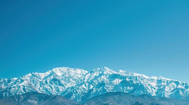 Scenic view of a snowy mountain range under a clear blue sky Nature