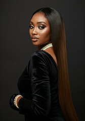 dark skin african american model wearing long ombre hair extensions pearls and a velvet black dress
