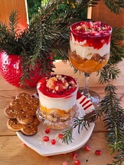 dessert of cookies with yogurt, nuts, tangerine and jam on the table by the Christmas tree
