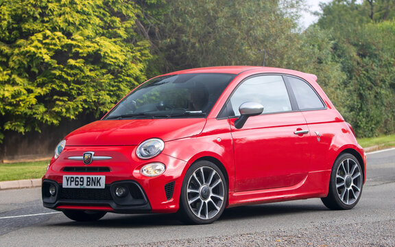 2019 red Abarth 595 car travelling on an English country road