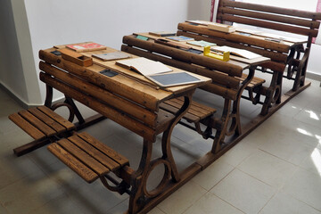 An old wooden school desk on display in a museum. We also see teaching aids.