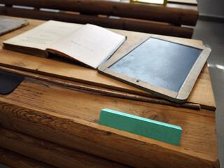 A close-up photo of an old school desk with old retro school supplies on it.