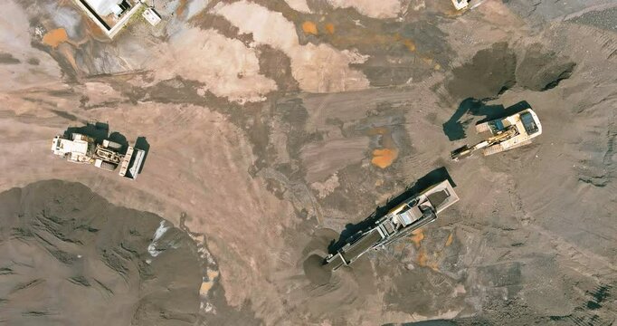 Heavy machinery operates on expansive land, reshaping stone preparing at stone quarry